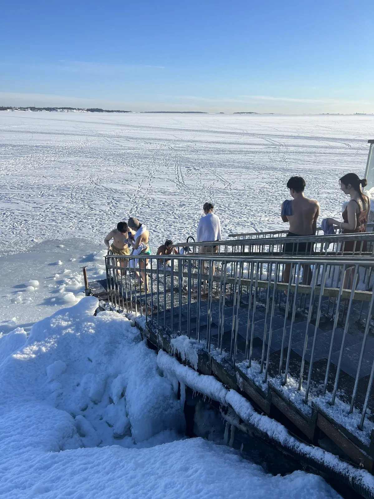 凍った海へ歩いて向かう氷水浴の入浴者たち